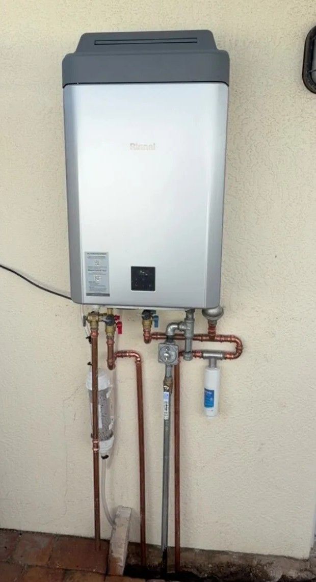 Wall-mounted water heater with exposed copper pipes and valves against a beige wall.