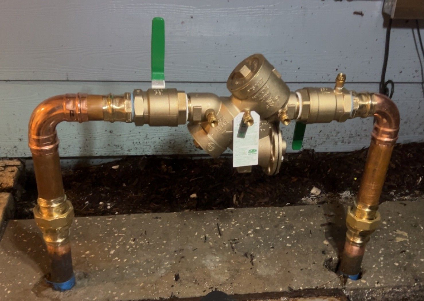 Industrial pump and piping system with blue valves and silver pipes in a mechanical room