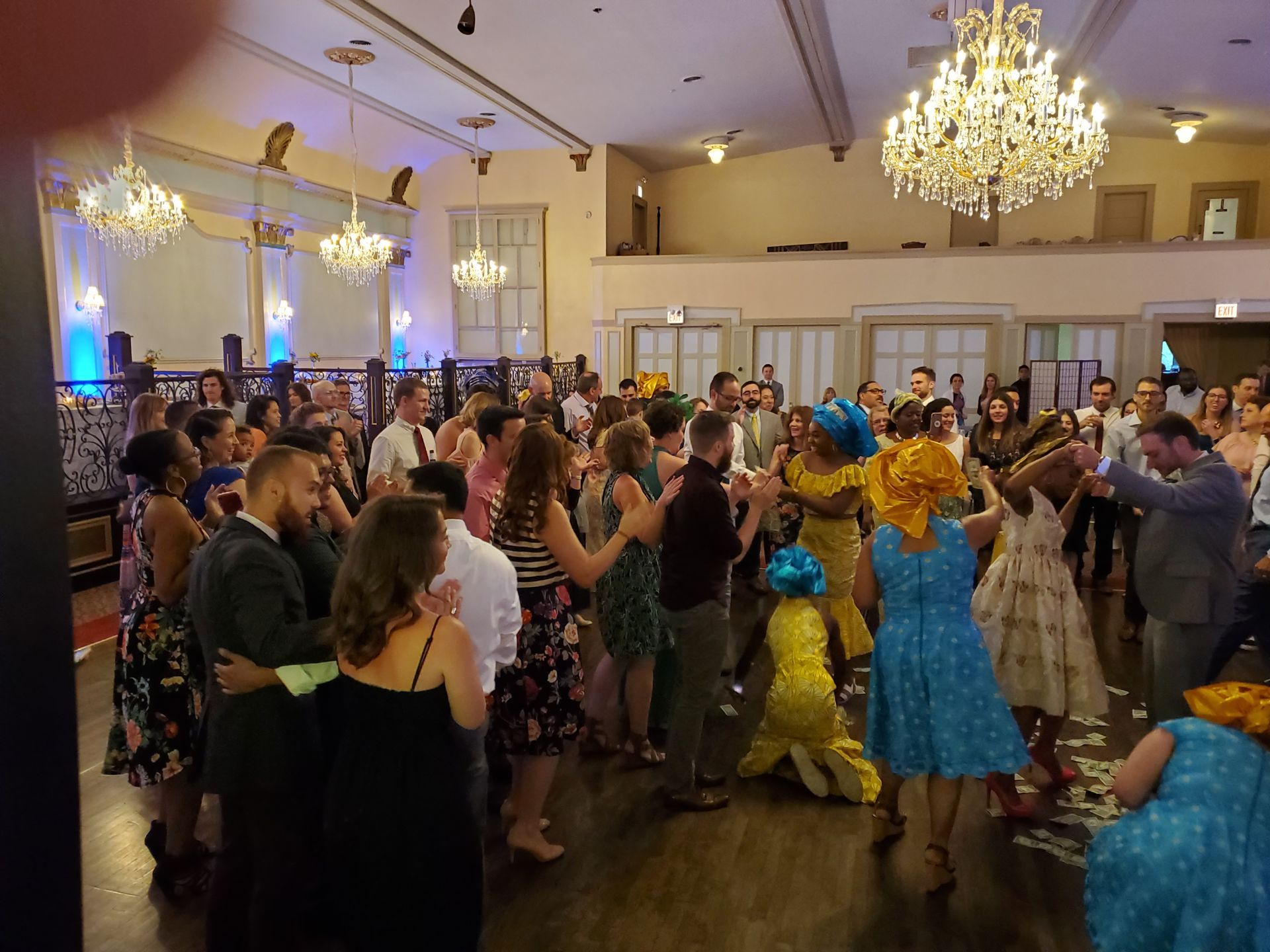 A large group of people are dancing in a large room.