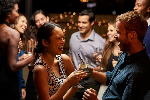 A group of people are having a party and toasting with champagne glasses.