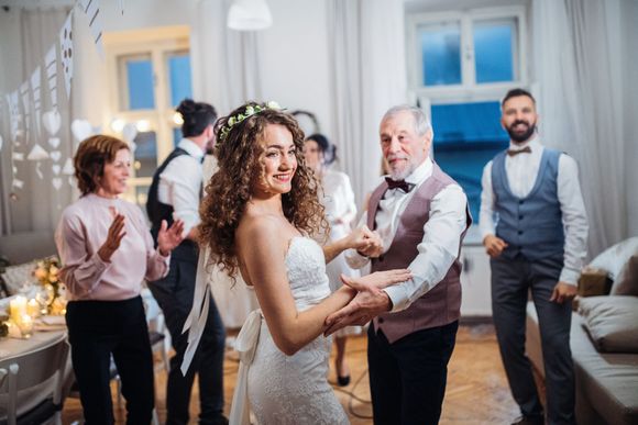 A bride and groom are dancing at their wedding reception.