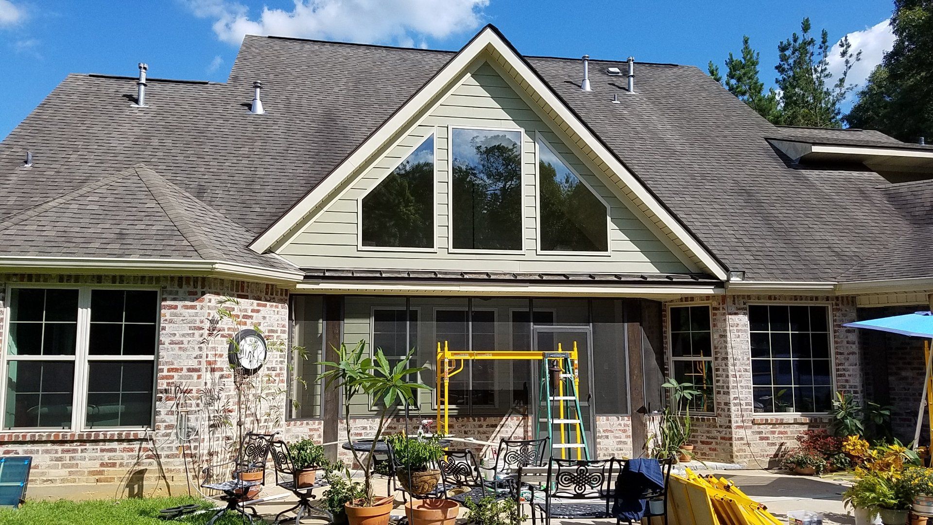 A large brick house with a gray roof and a lot of windows