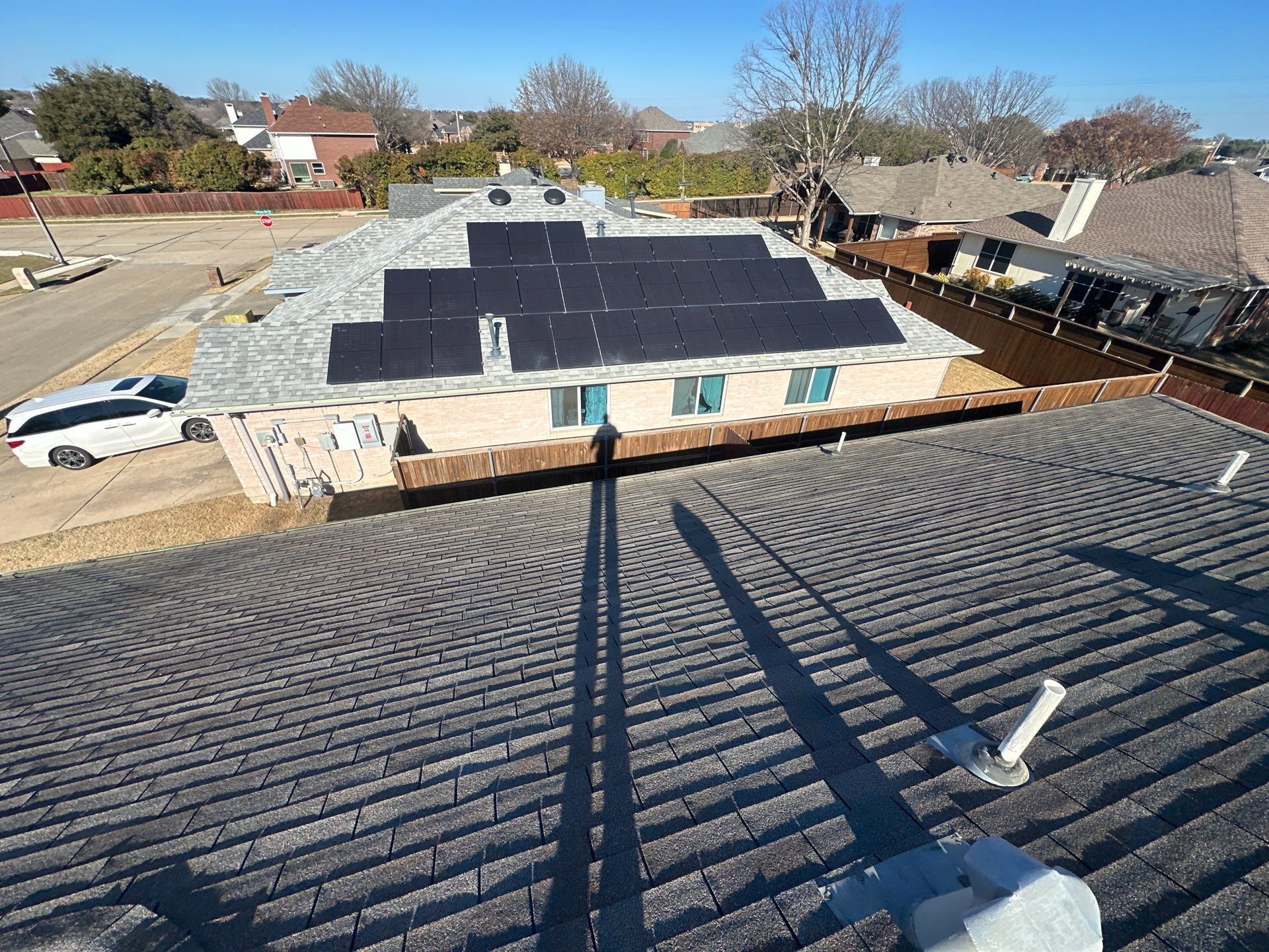 Rooftop solar panels on a flat-roof building in a suburban neighborhood