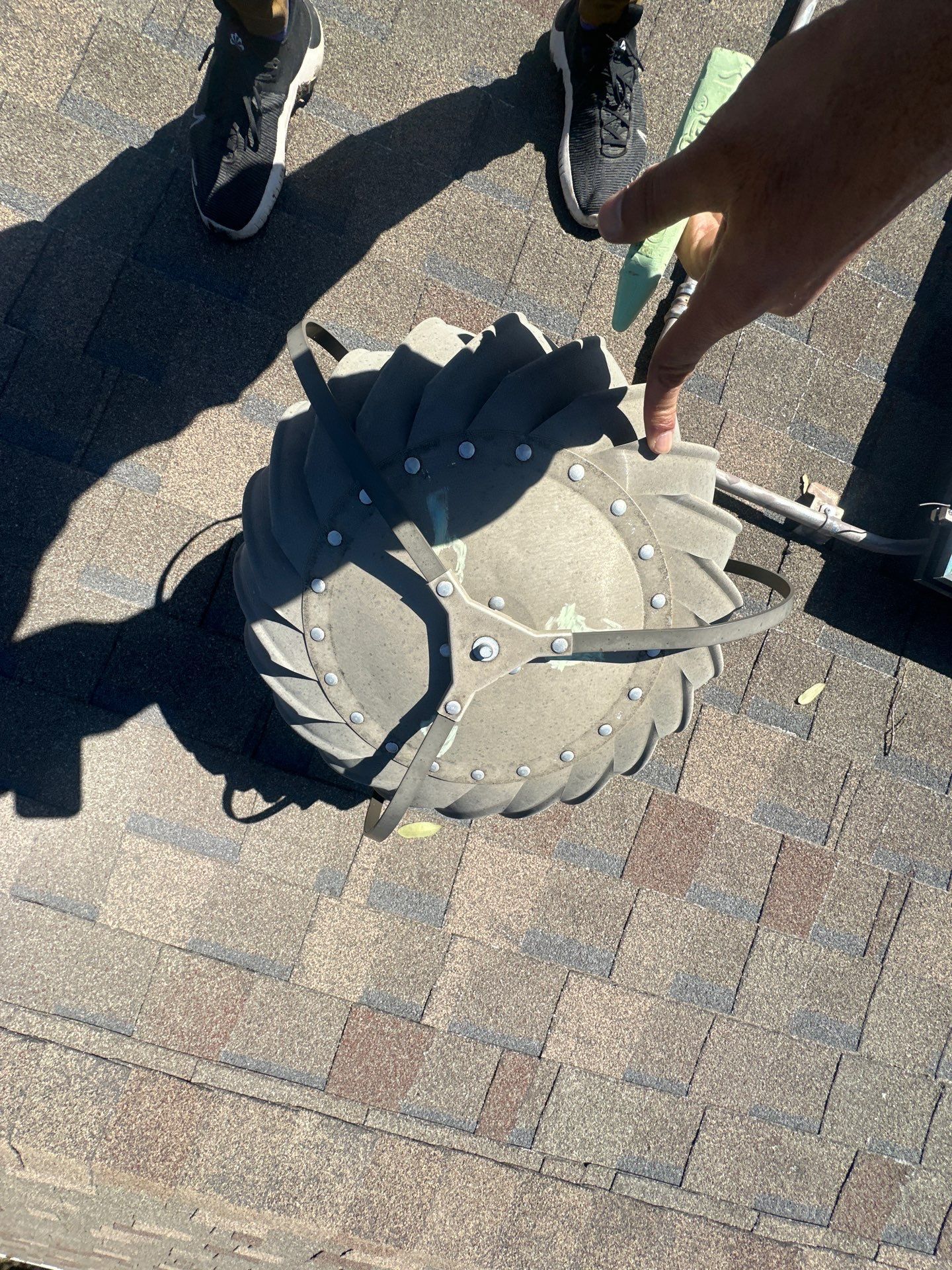 Hands adjusting a gray backpack on a brick pavement рядом with two people’s feet