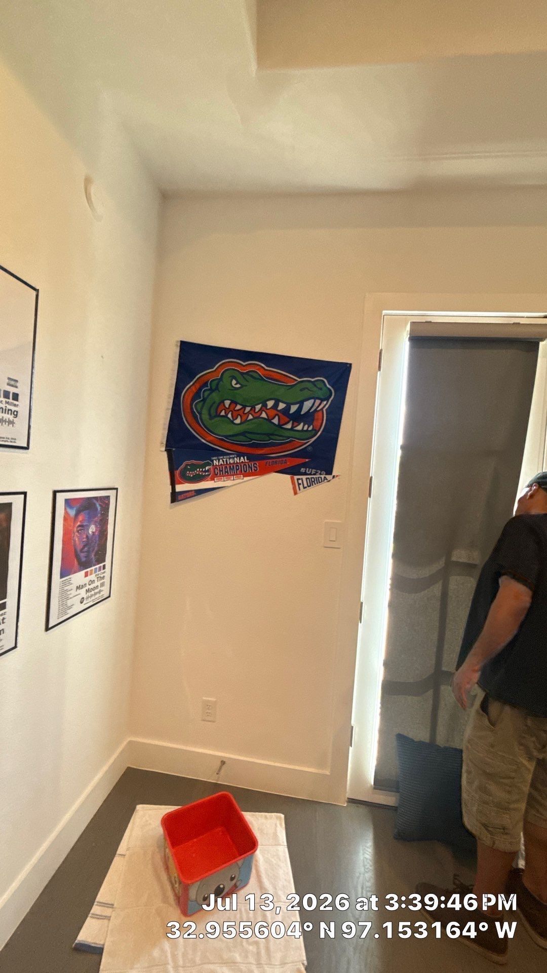 Hallway with Florida Gators flag on the wall and a person standing by a doorway
