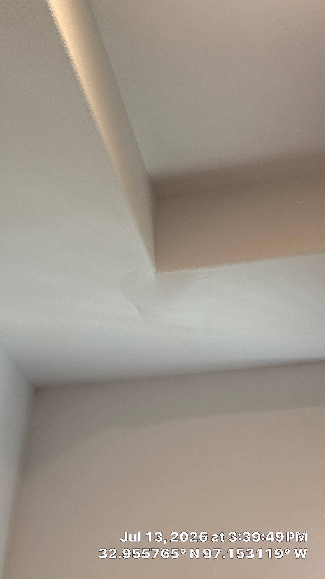 Ceiling corner with recessed lighting and a wall junction, viewed indoors.