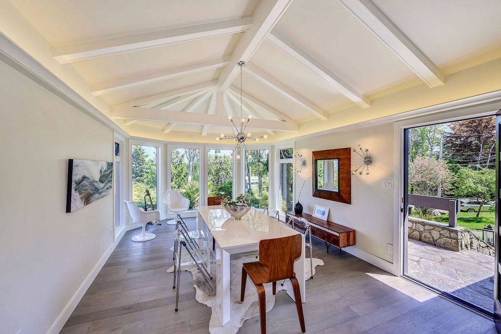 A dining room with a table and chairs and a large window.