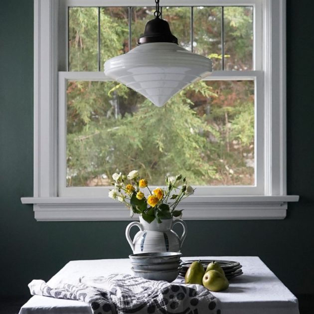 A table with a vase of flowers on it in front of a window