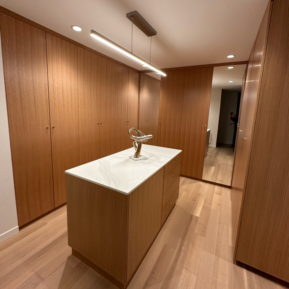 A walk in closet with a large island in the middle