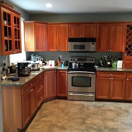 A kitchen with wood cabinets, stainless steel appliances, and gray countertops.