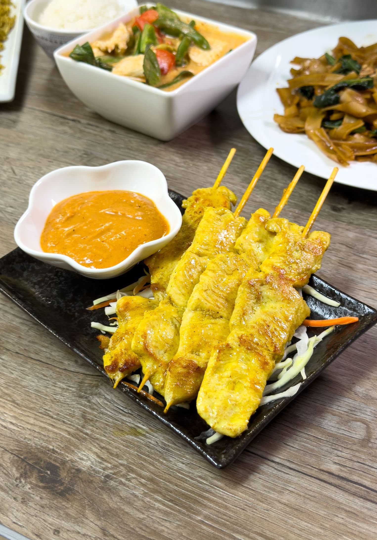 A plate of food with a bowl of dipping sauce on a table.