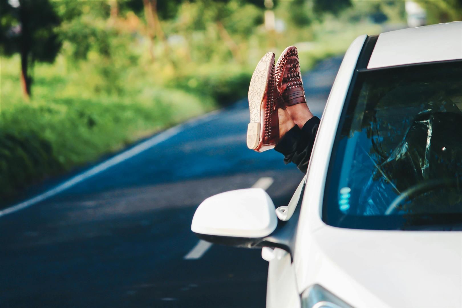 A person is sticking their feet out of the window of a car. | Walt's Auto Service