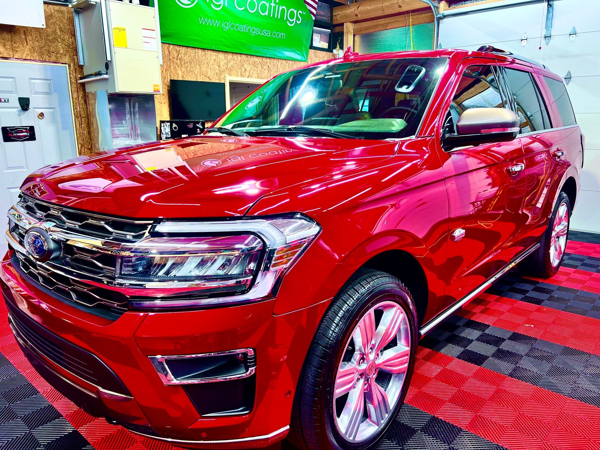 Red SUV displayed indoors on a red carpeted showroom floor