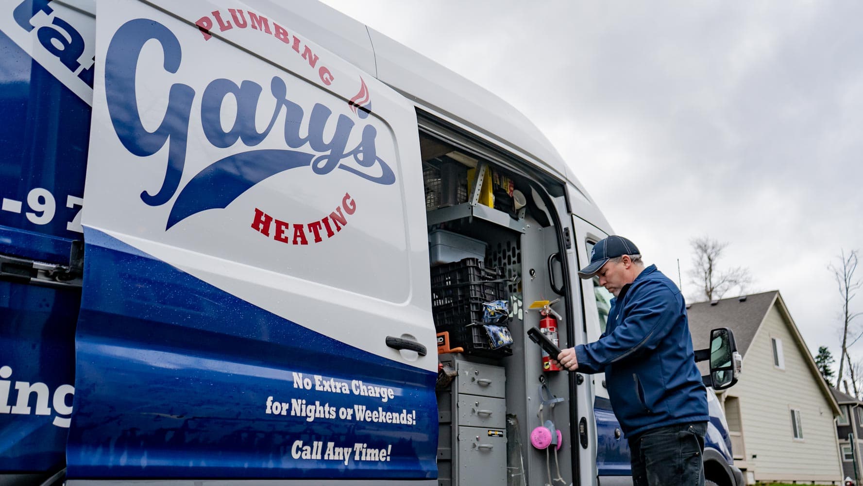 A plumber is working on a pipe in a van.