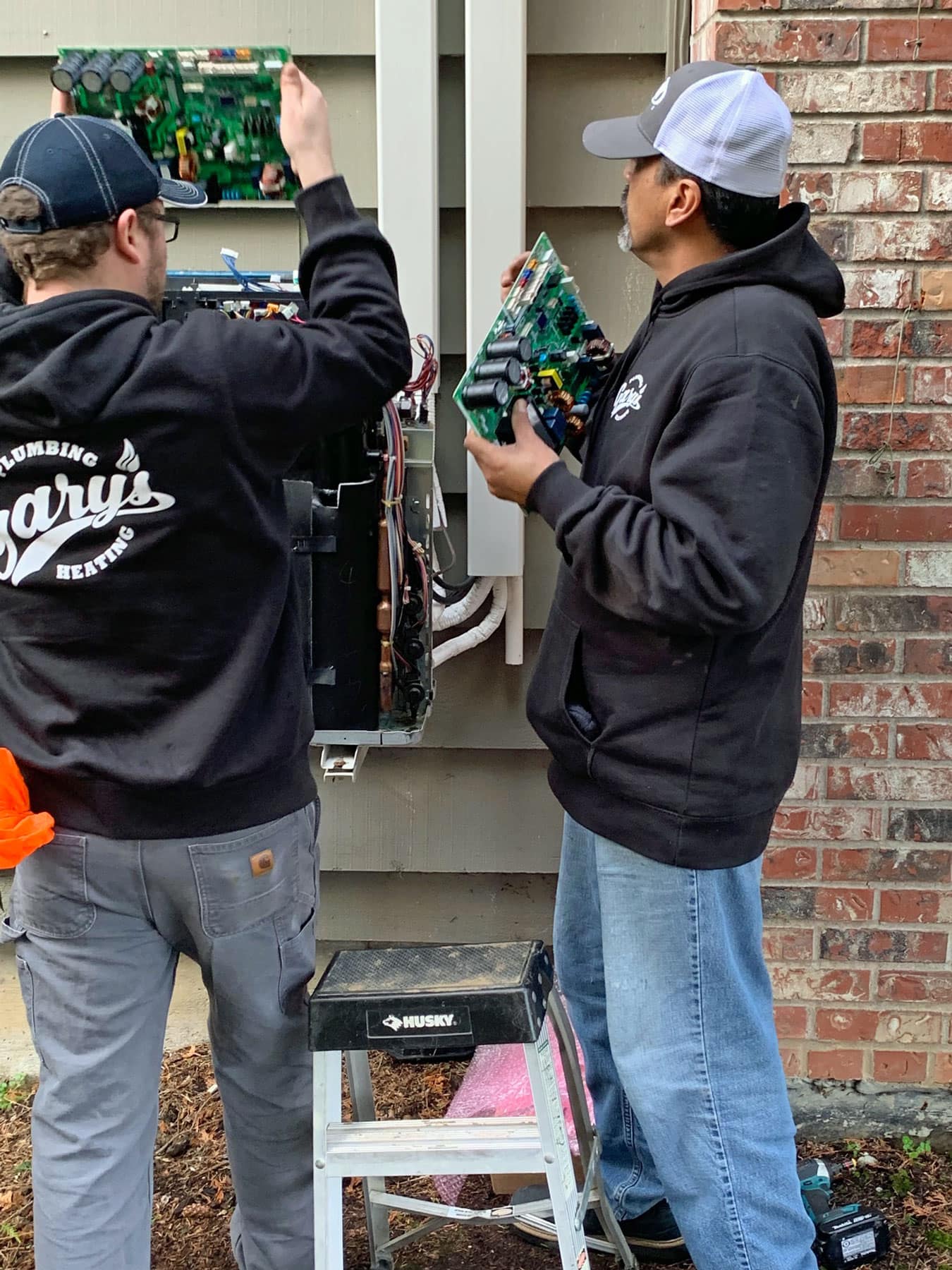Photo of a plumber repairing a heating unit