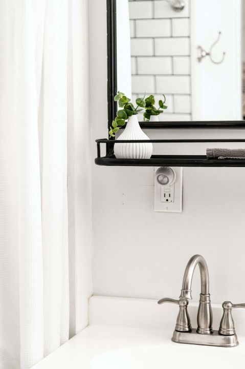 A bathroom sink with a mirror and a shelf above it.
