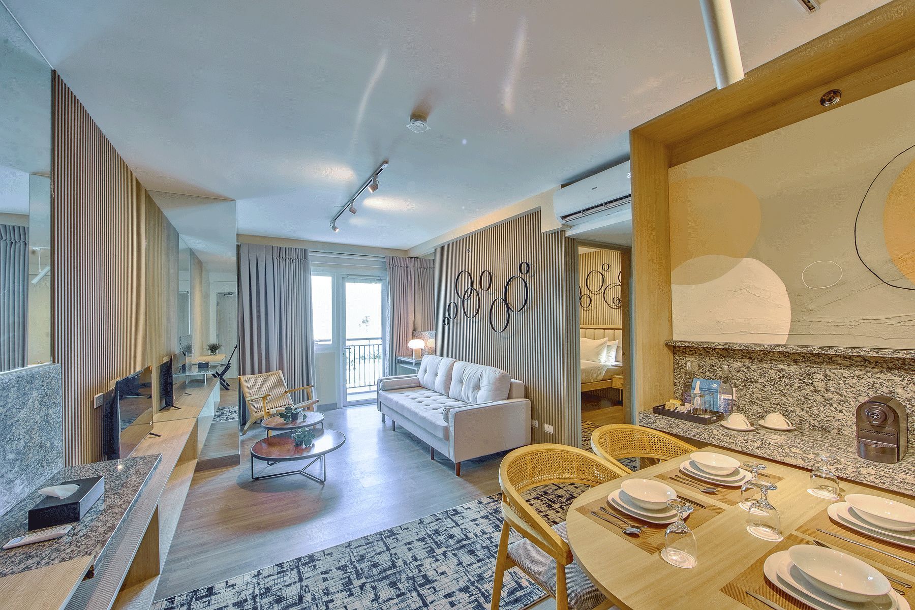Living and dining area of serviced apartment for rent at The Connor with balcony view near Greenhills