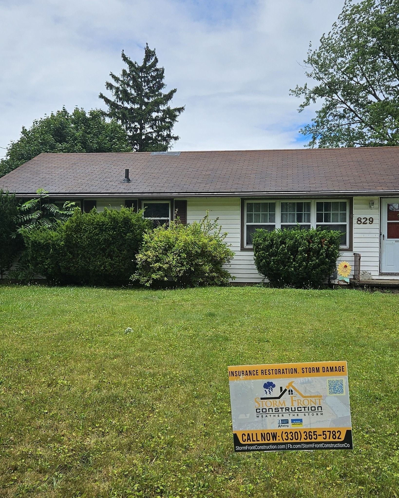 Single-story white house with a front lawn and a real estate sign in the yard.