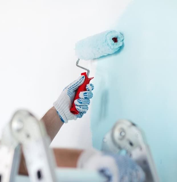 A Person Is Painting A Wall With A Paint Roller — Greg Cannon Painting In Lake Macquarie, NSW