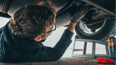 a mechanic doing an auto repair under the hood of a car