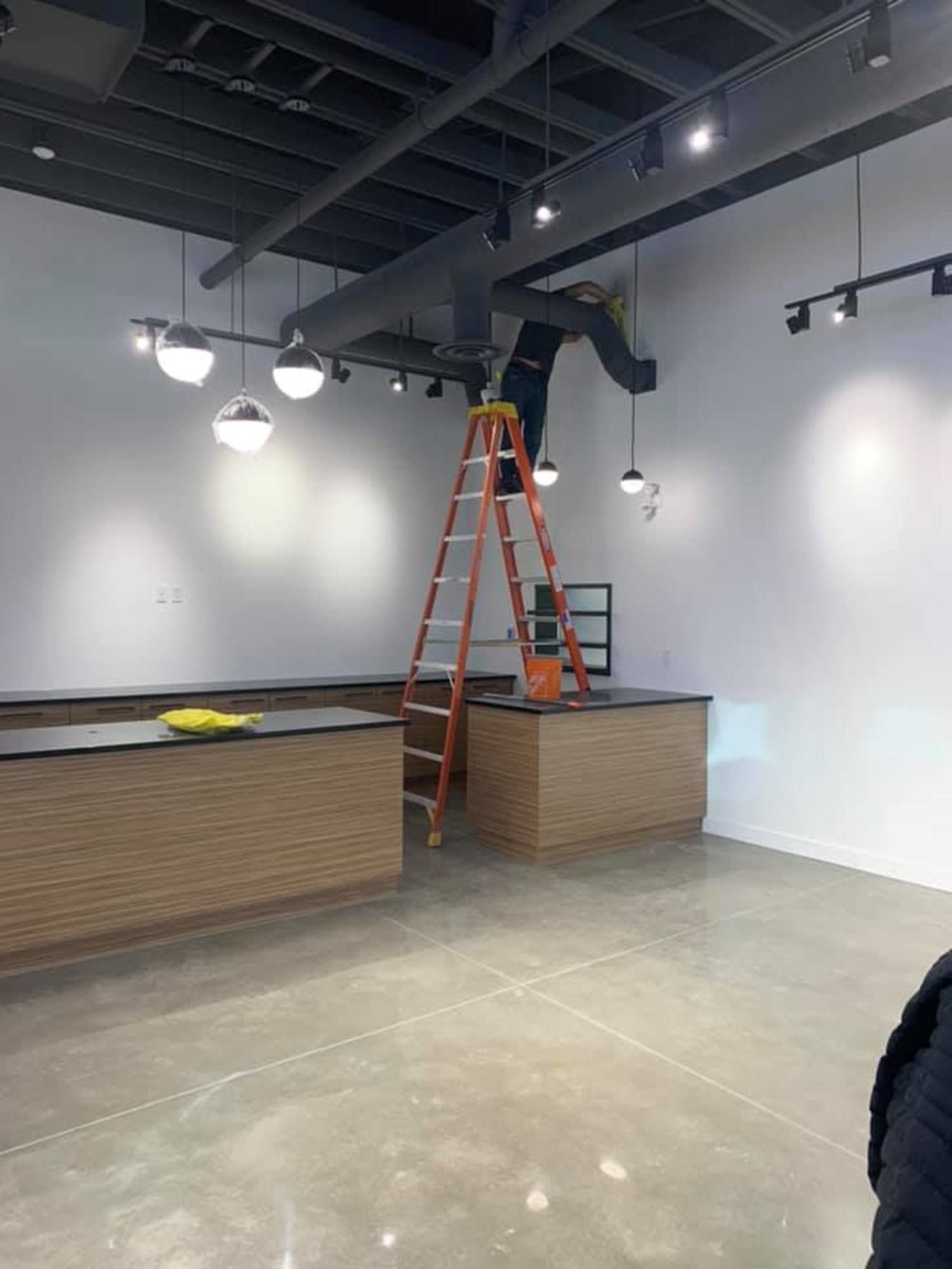 Technician performing high ceiling dusting and commercial vent cleaning