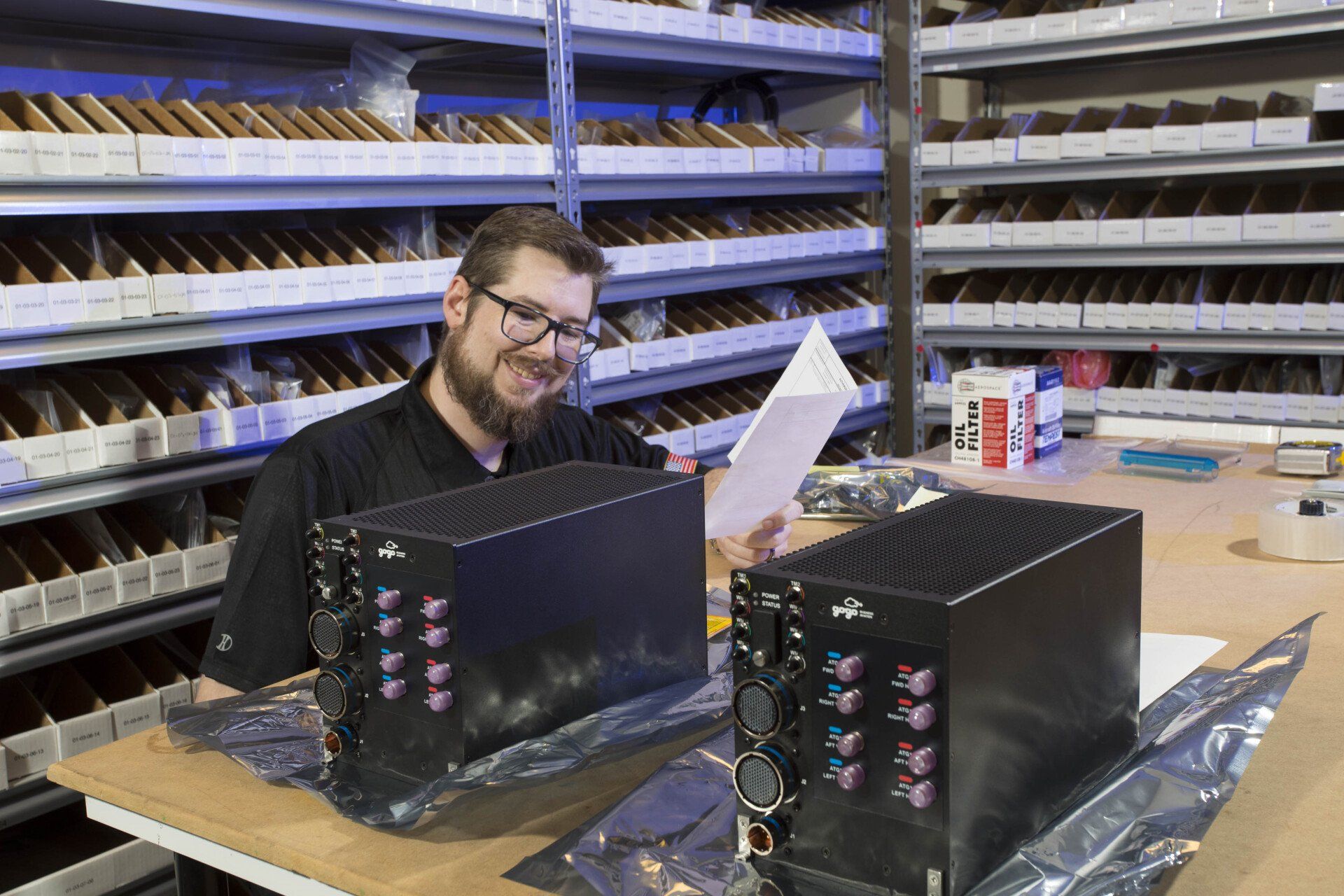 A man is sitting at a table in a warehouse looking at a piece of paper.