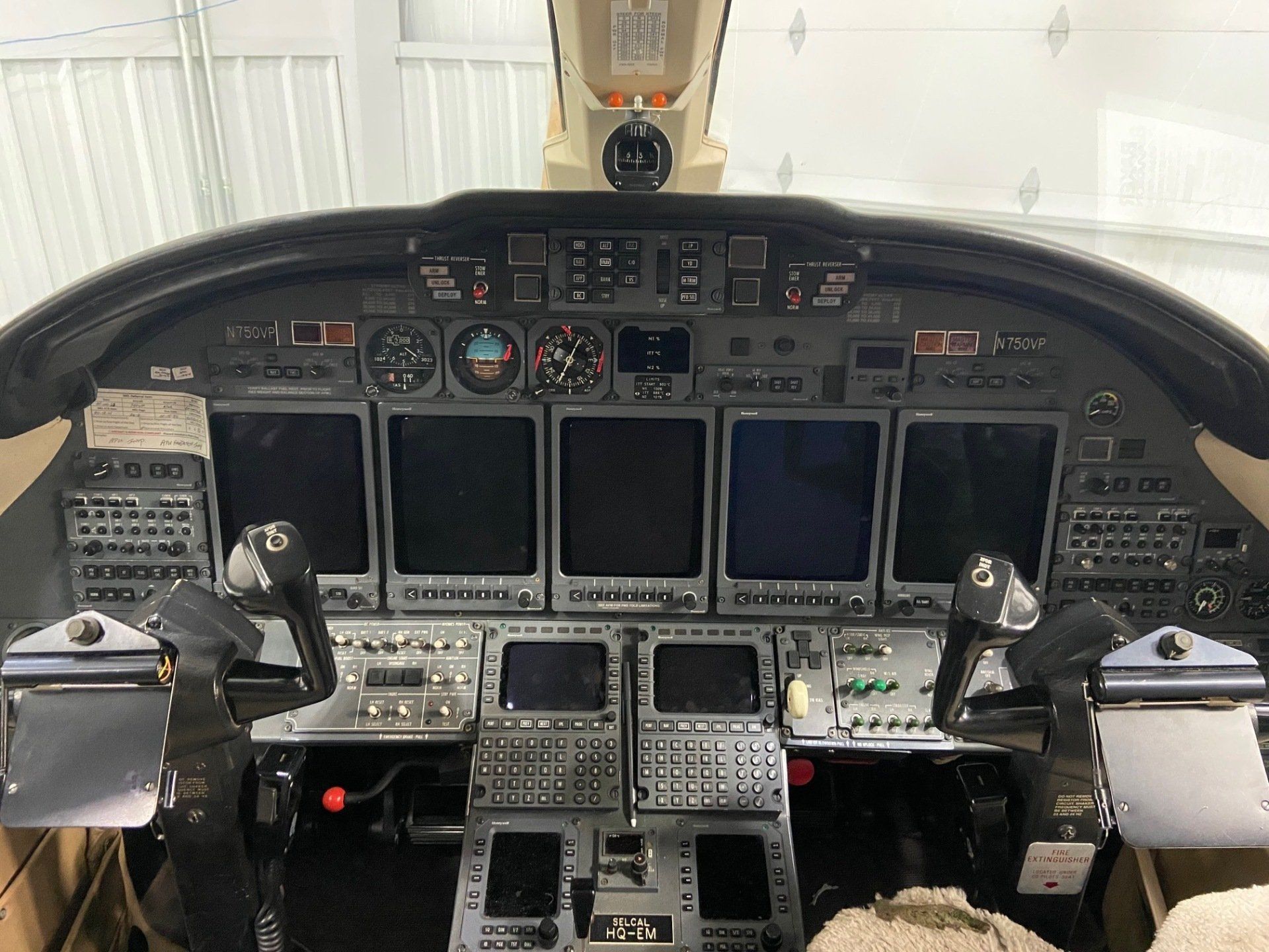 A cockpit of an airplane with many monitors and buttons
