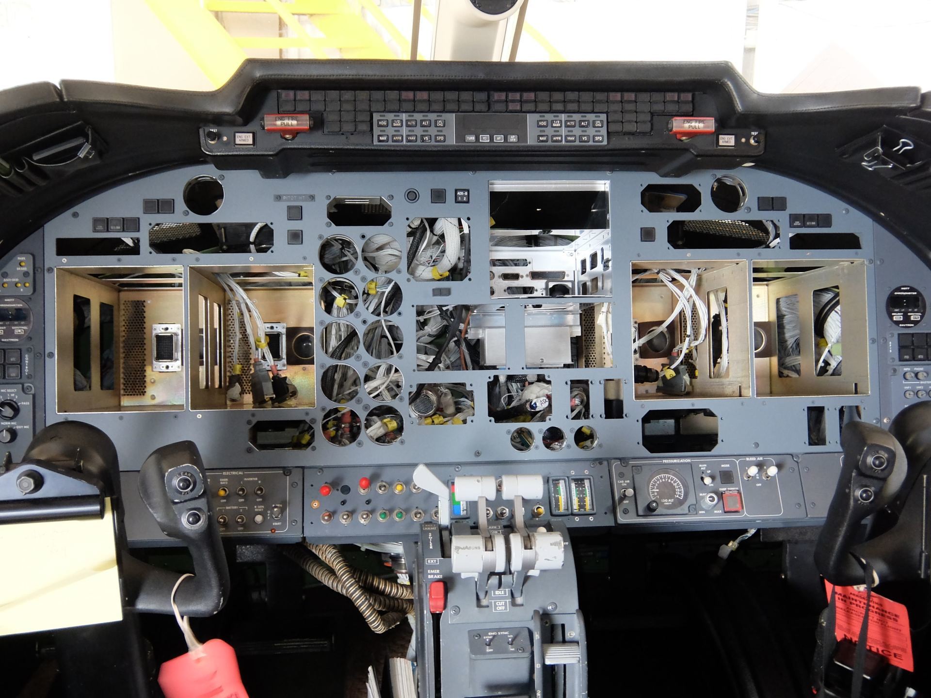 A cockpit of an airplane with the dashboard removed
