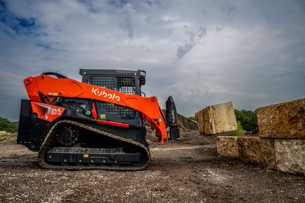 A tractor with a chainsaw attached to it is parked in a field.