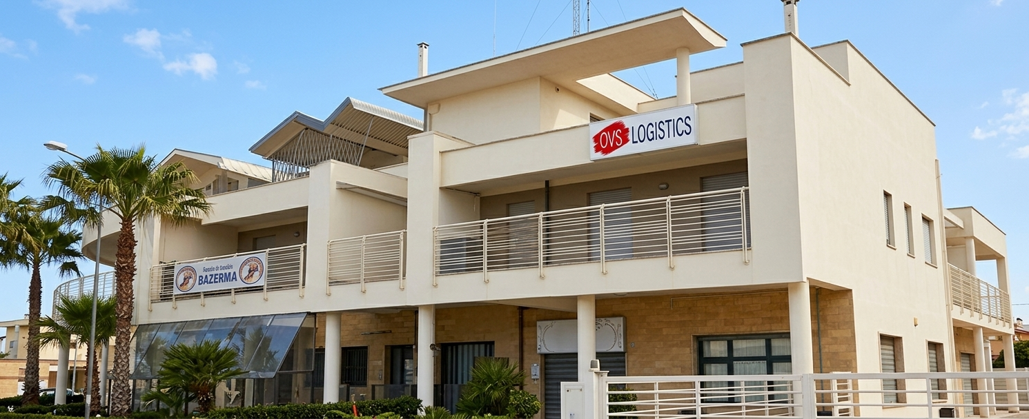 Modern beige office building with a sign and palm trees outside