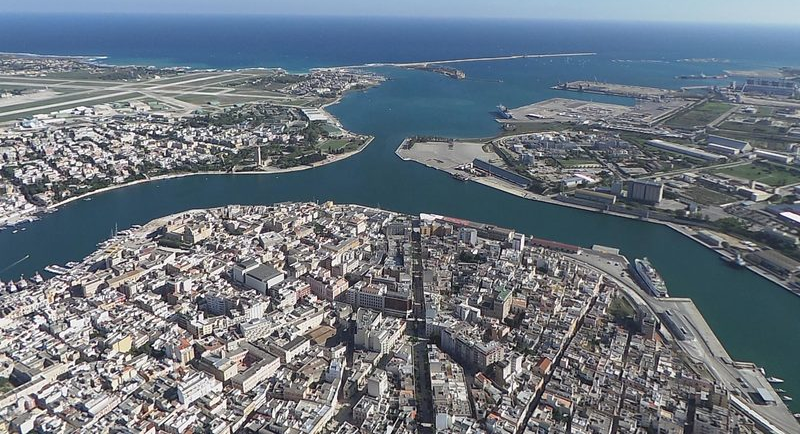 Aerial view of a coastal city with river inlets and a blue ocean horizon