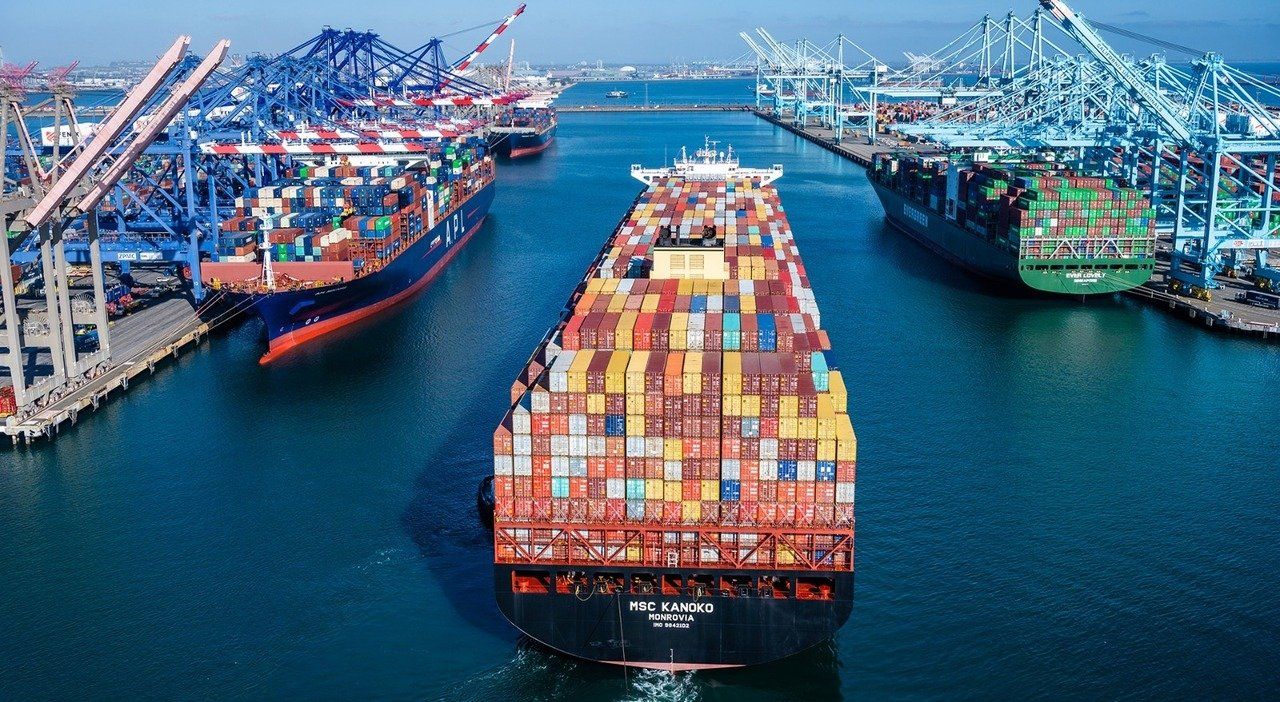 Large container ship in a busy port with colorful cargo containers and cranes on both sides