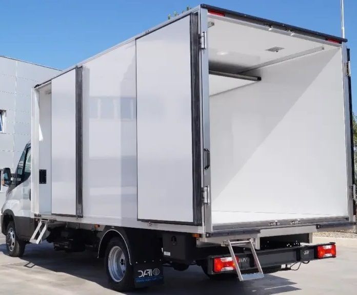 White refrigerated delivery truck with open rear cargo door parked outdoors