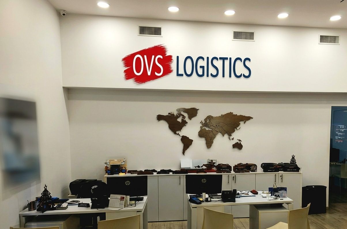OVS Logistics office reception with desks, world map wall art, and ceiling lights