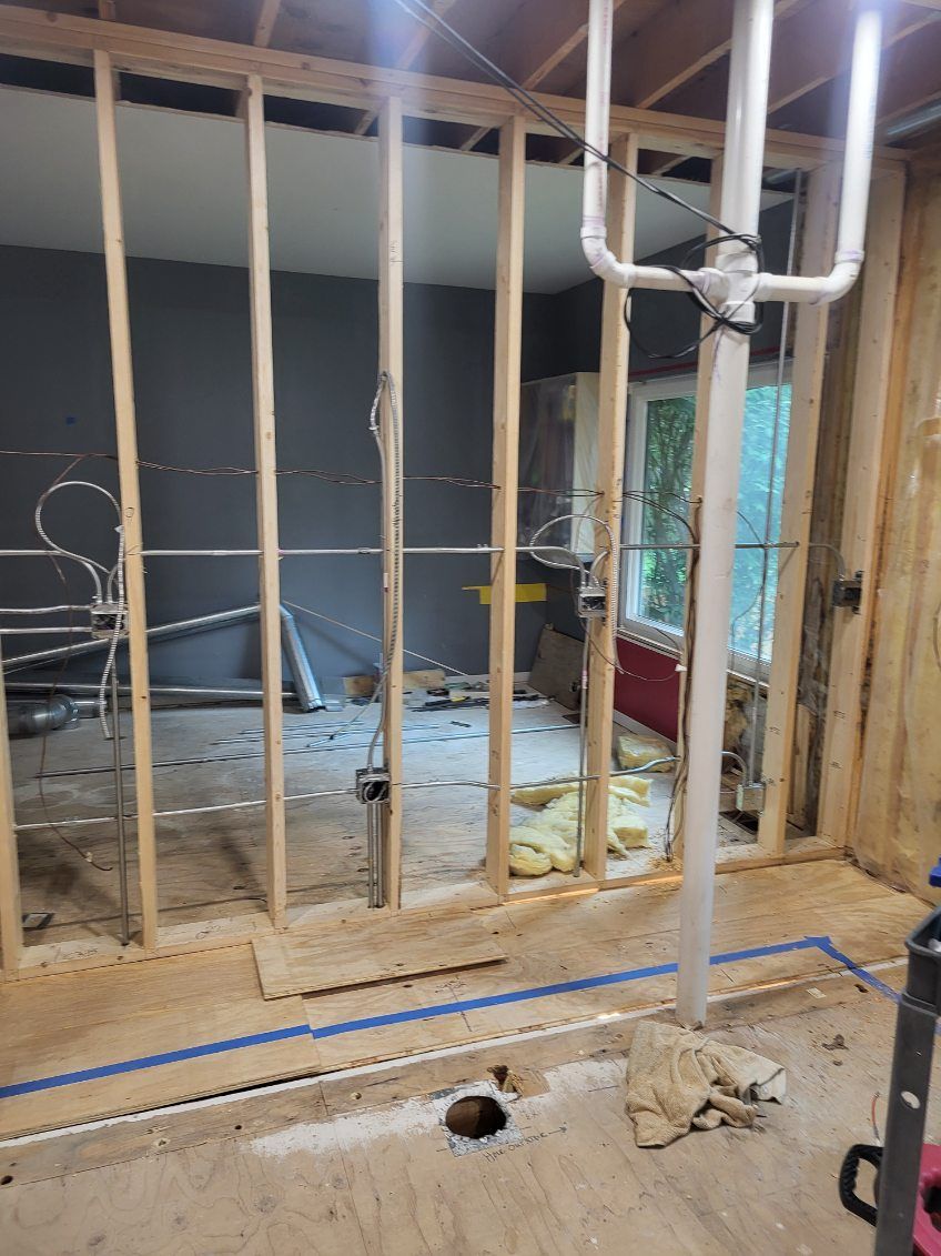 Electrical conduit and wiring installation during interior remodeling with framed walls and studs in progress by N Electric