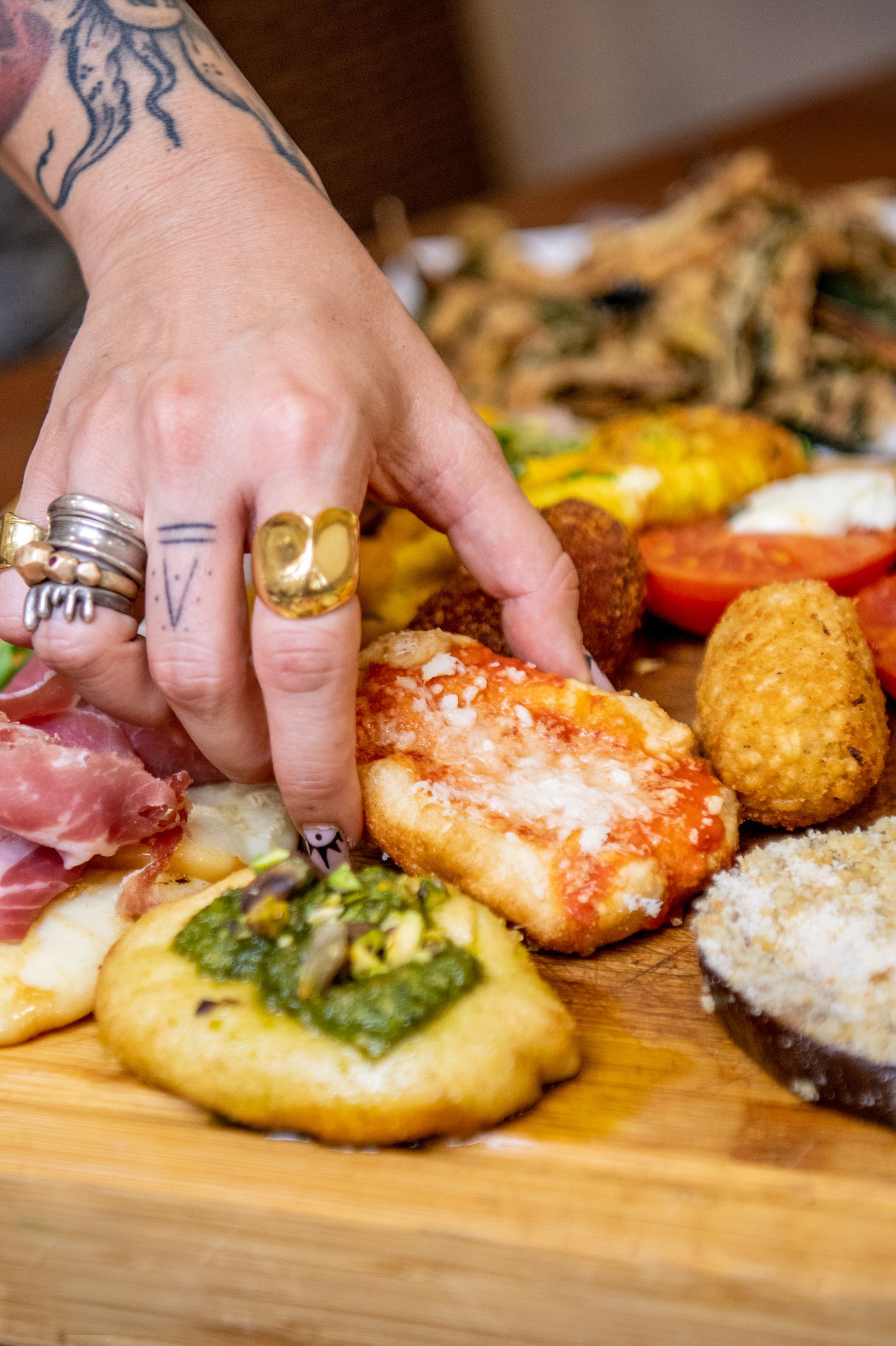 Selezione a mano di pesce arrosto e altri antipasti su un tagliere di legno