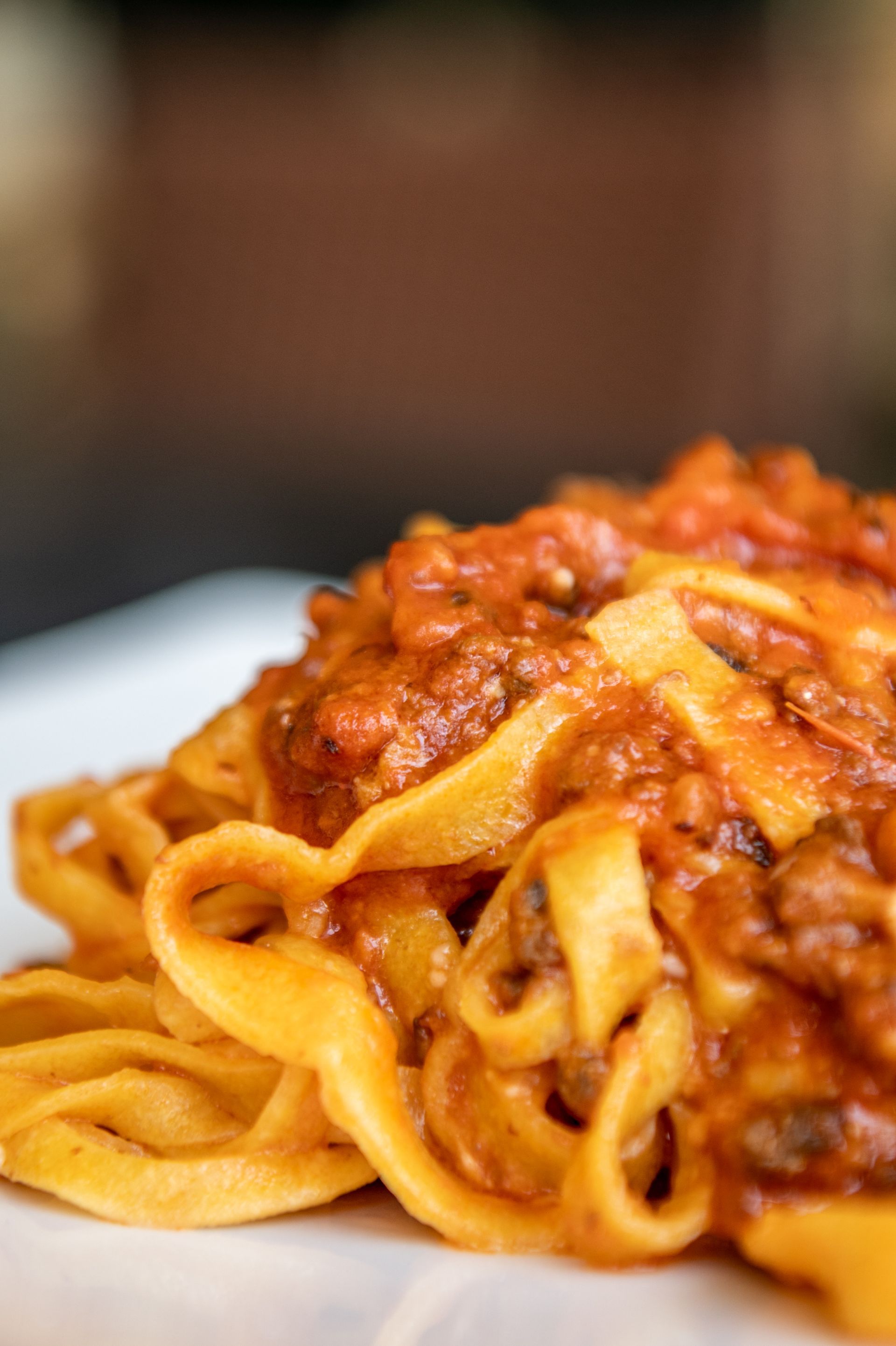 Primo piano di pasta al sugo di carne e pomodoro in un piatto