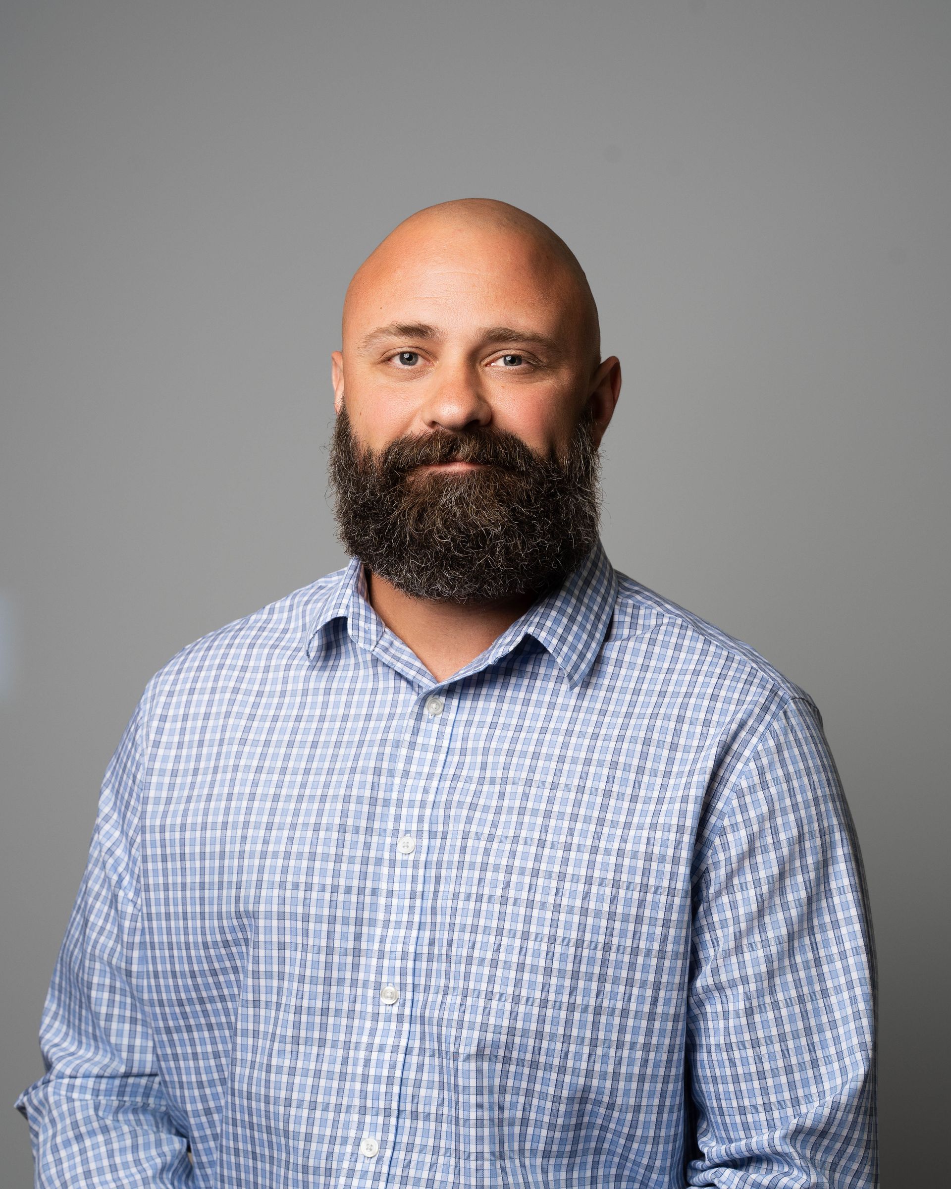 A man with a beard is wearing a suit and tie.