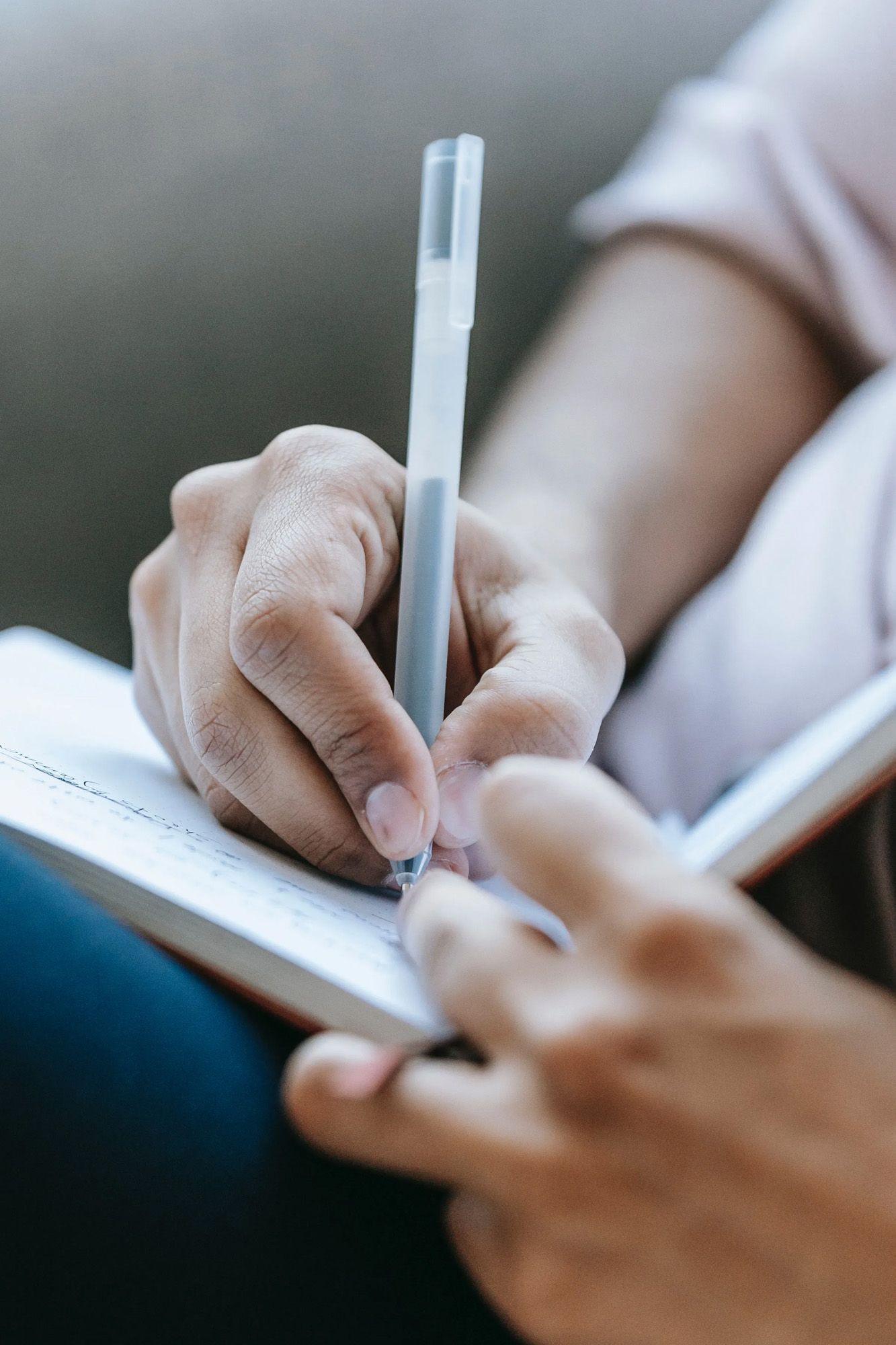 A person is writing on a checklist in a notebook.