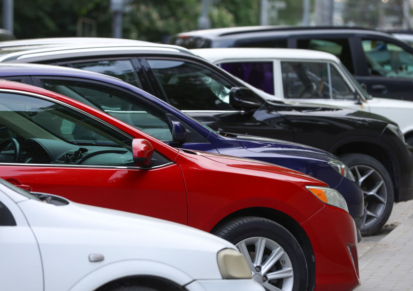 Person standing beside a rental car while waiting for their new vehicle in Adelaide.