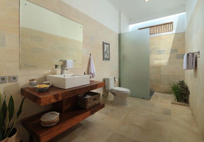 Bathroom with a floating wooden vanity, large mirror, frosted glass shower, and neutral color scheme.