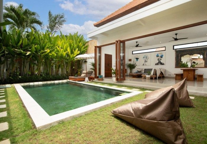 Pool and villa exterior: swimming pool, lounge area, lush greenery, and modern architecture.
