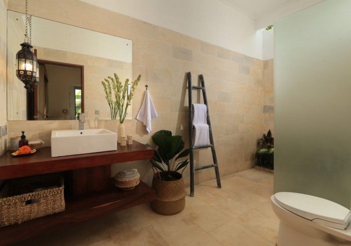 Bathroom with a wooden vanity, large mirror, and a frosted glass shower.