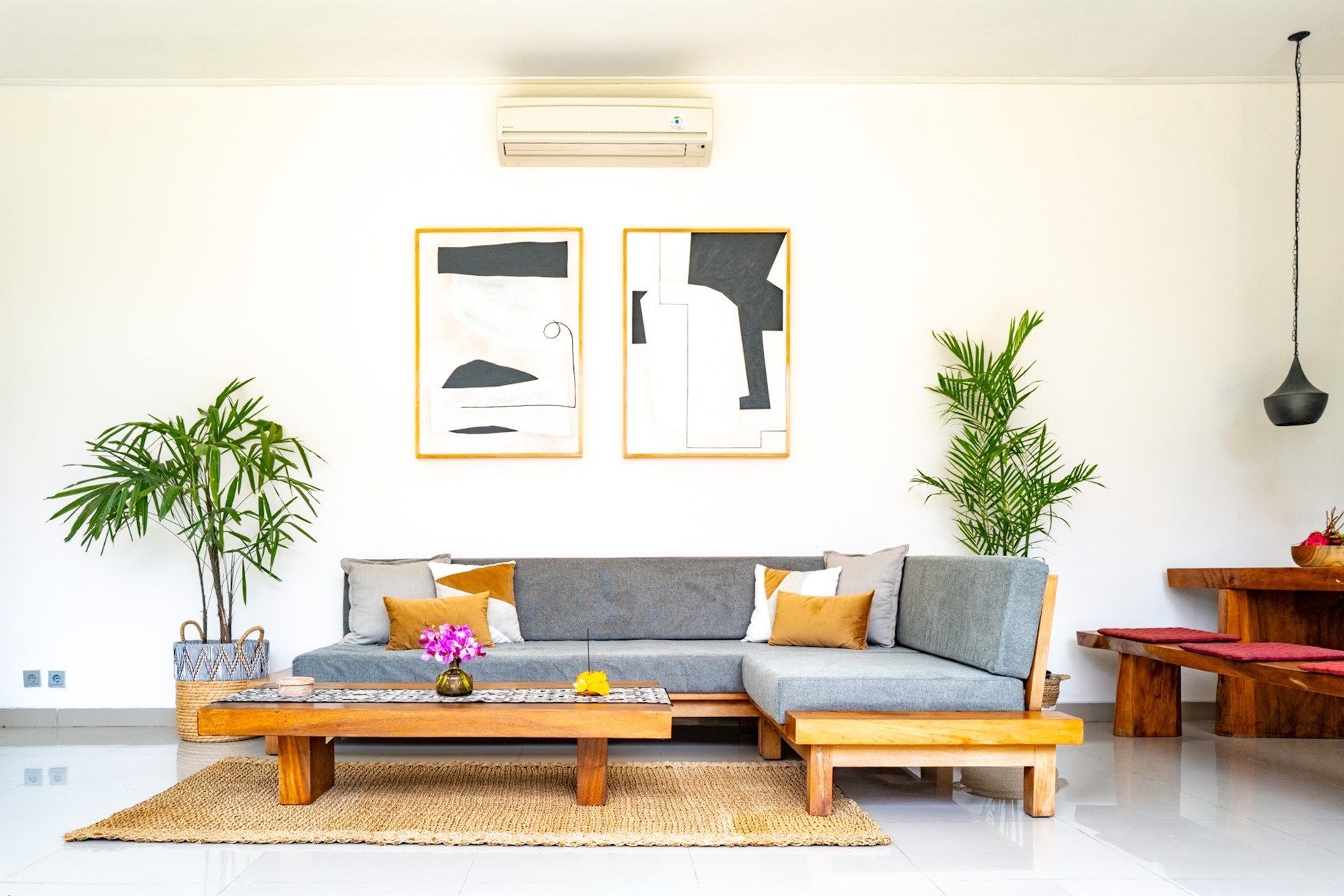 Modern living room with a gray sectional sofa, art, and plants.