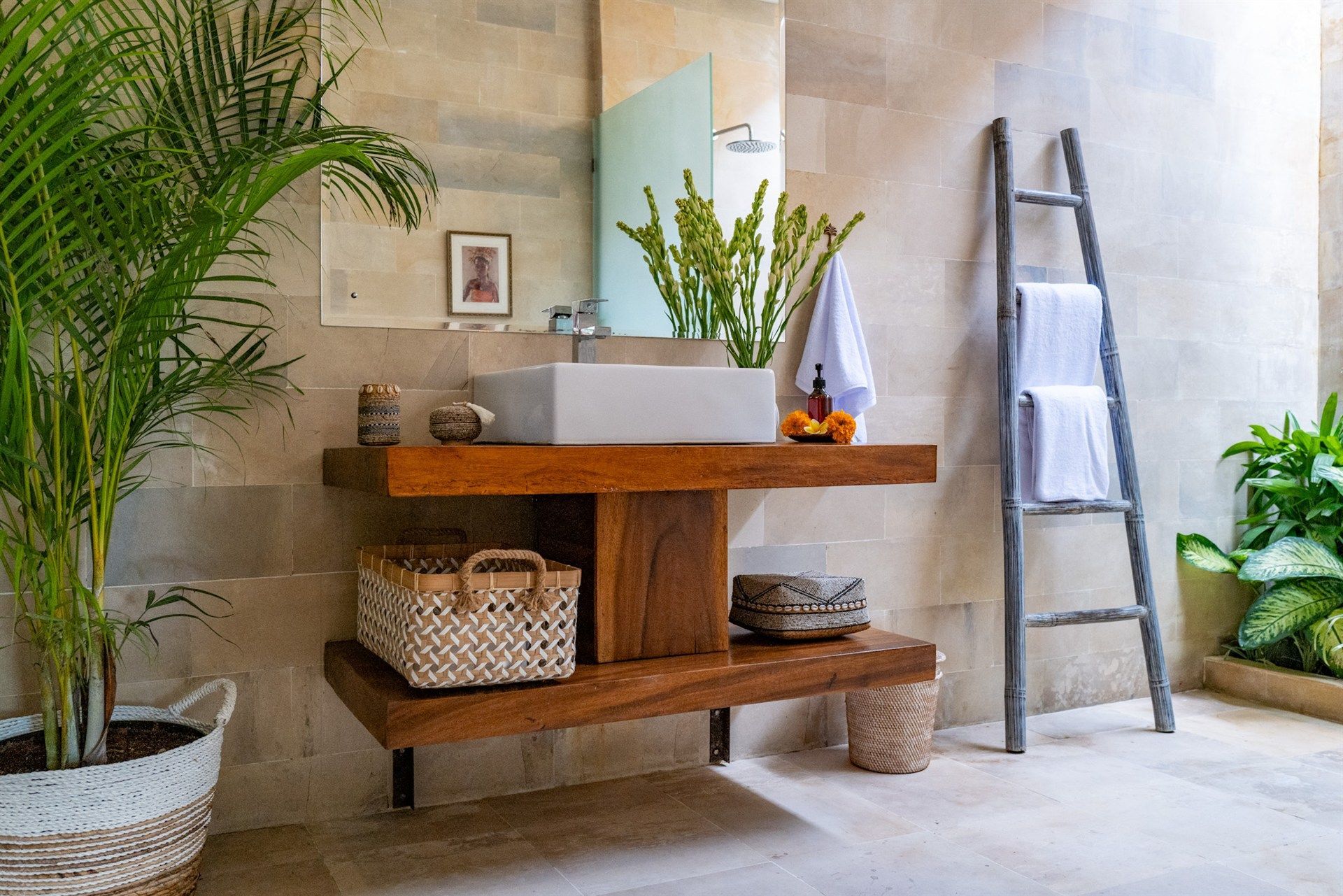 Bathroom with wooden vanity, white sink, and decorative ladder holding towels.