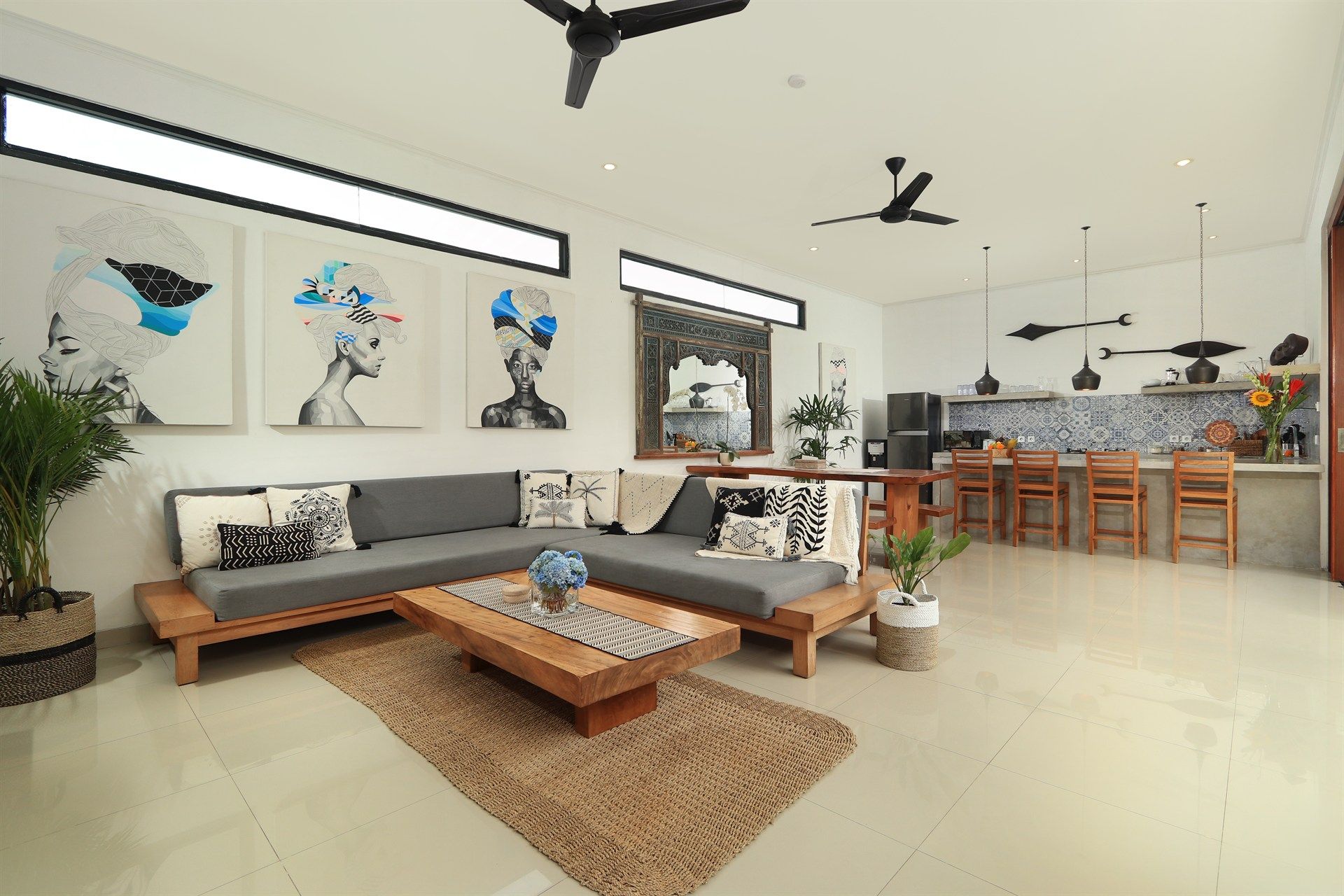 Modern living room with art, a sectional sofa, and an open kitchen.