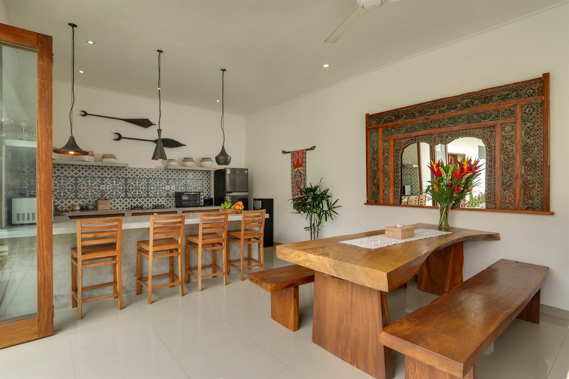 Kitchen and dining area with wooden table, bar stools, and decorative elements.