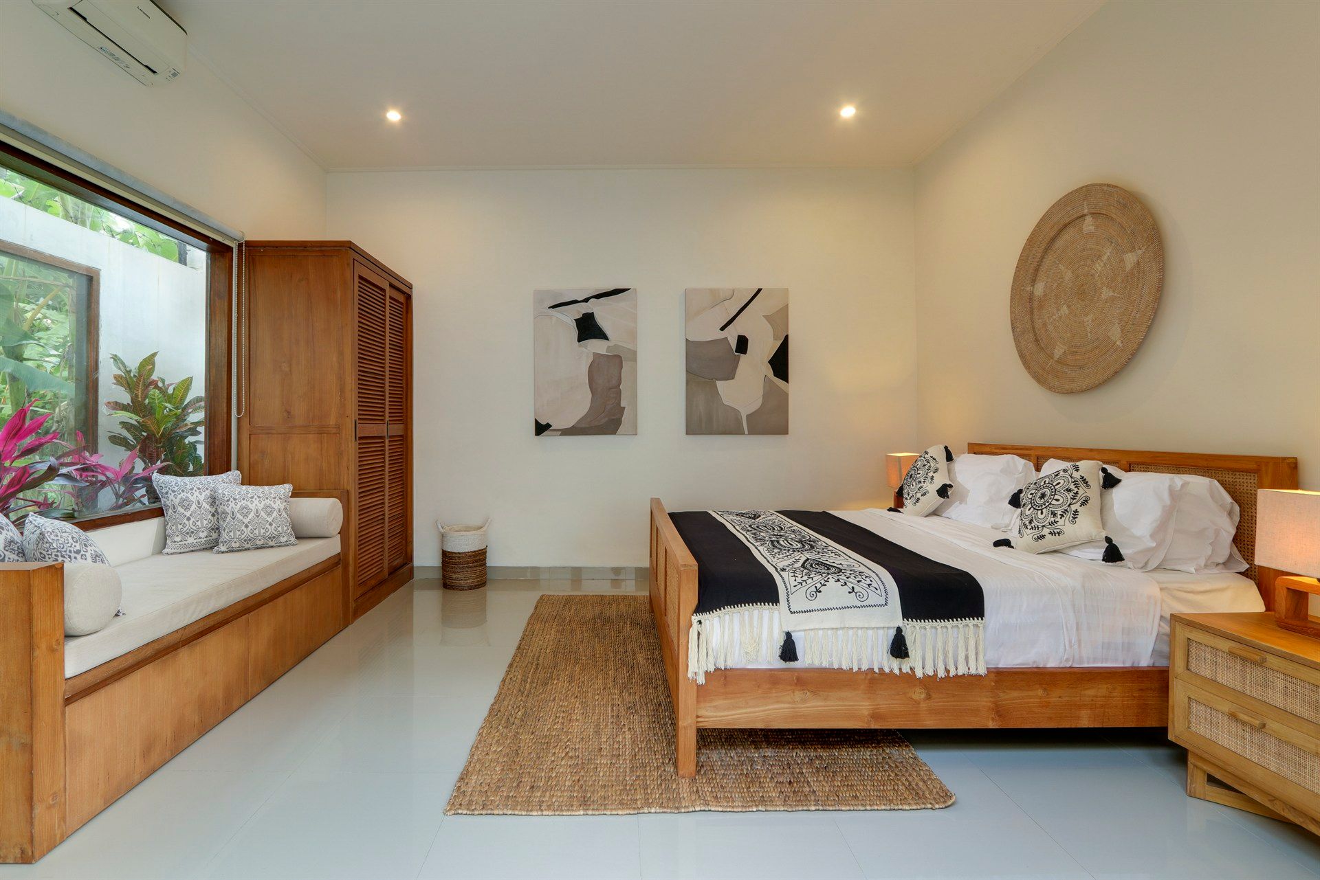 Bedroom with wooden bed, wardrobe, and window seat, decorated in neutral tones.