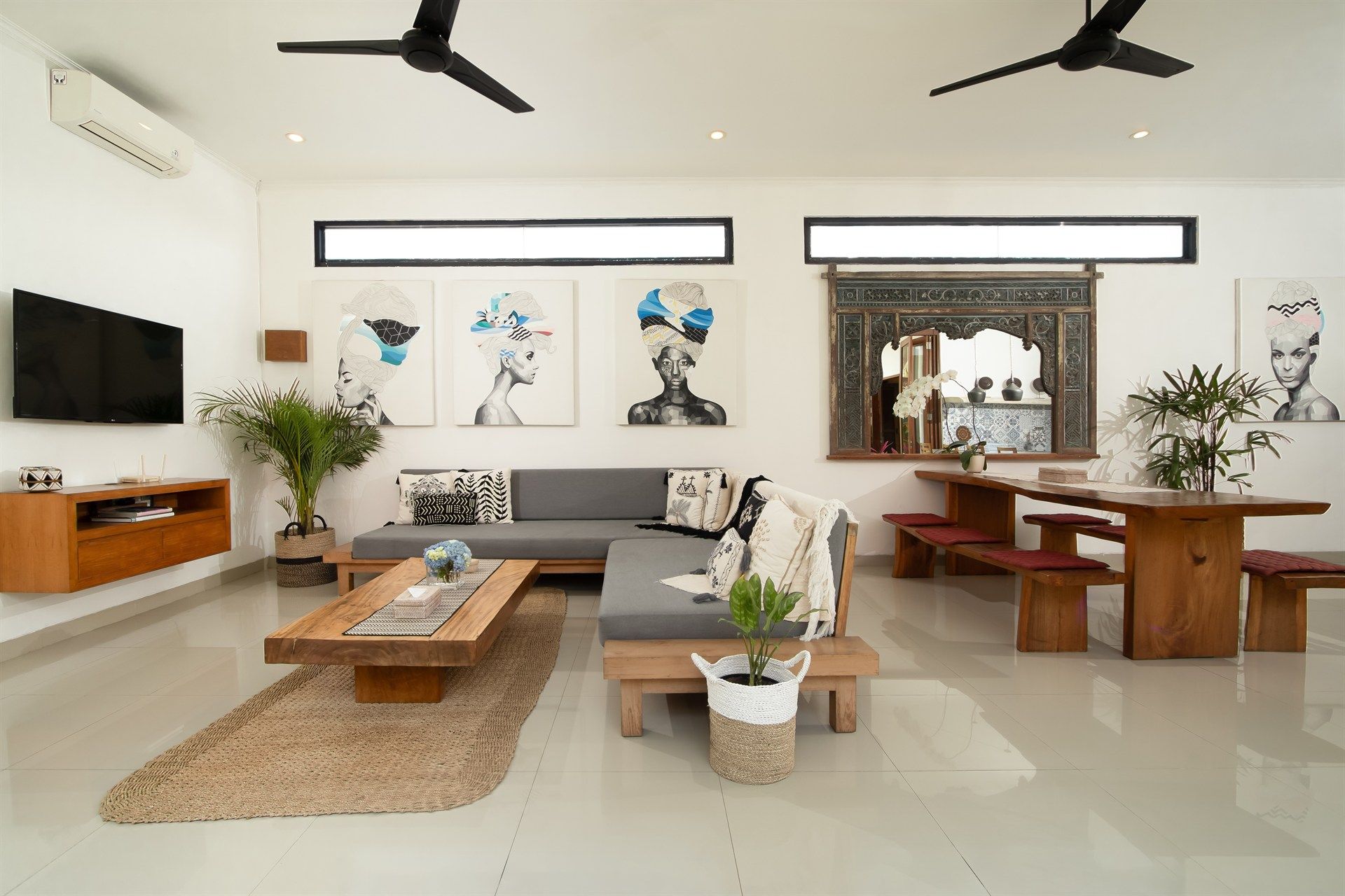 Bright, open-plan living space with a modern, minimalist design. Features a sectional sofa, wooden table, and dining set.