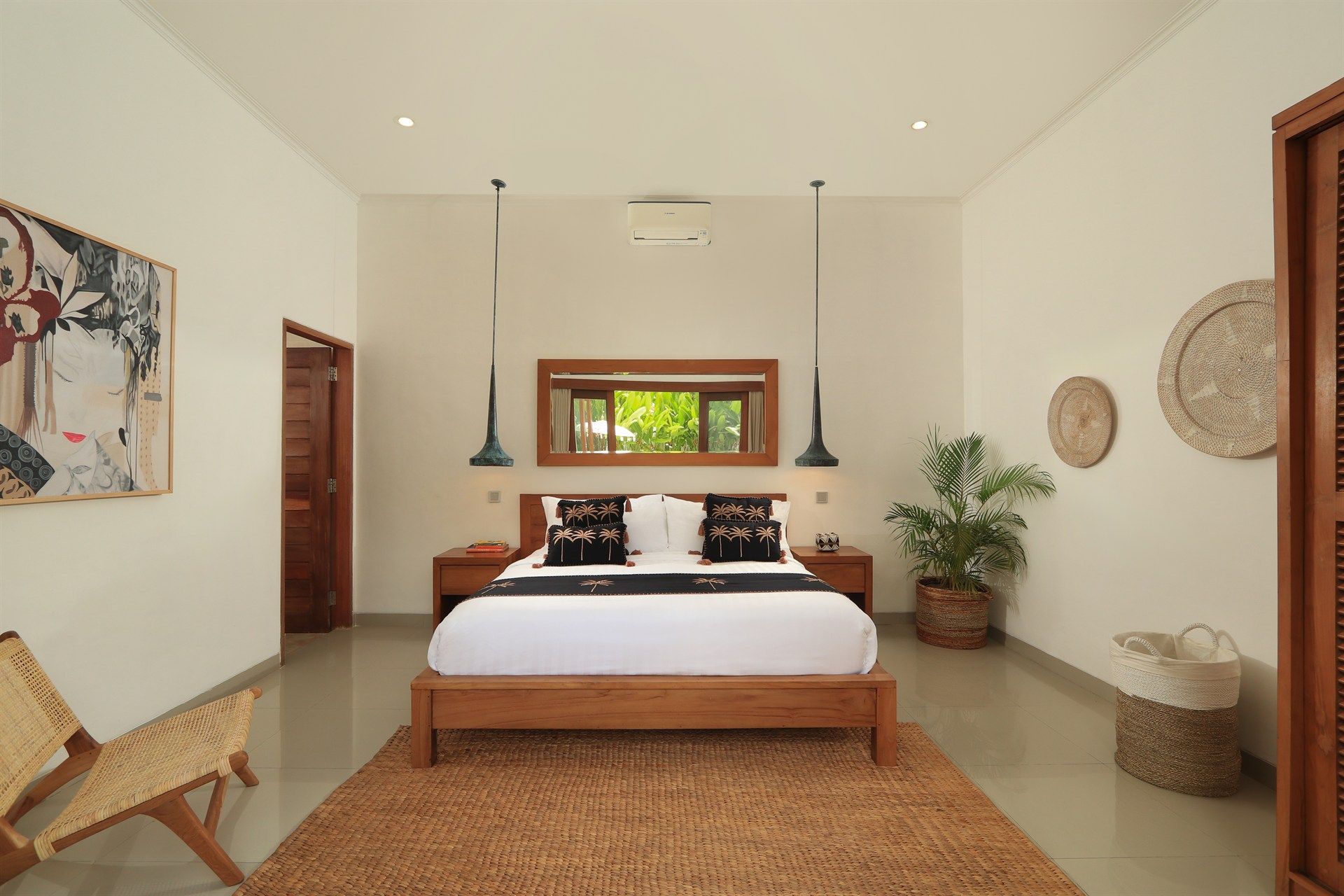 Bedroom with white walls, wooden furniture, and a natural fiber rug.